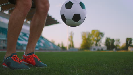 Incline-Hacia-Arriba-Con-Cámara-Lenta-De-Un-Hombre-De-La-Liga-De-Fútbol-Profesional-Haciendo-Malabarismos-Con-La-Pierna-En-El-Campo-De-Juego-Al-Aire-Libre-En-Un-Día-Soleado-De-Verano